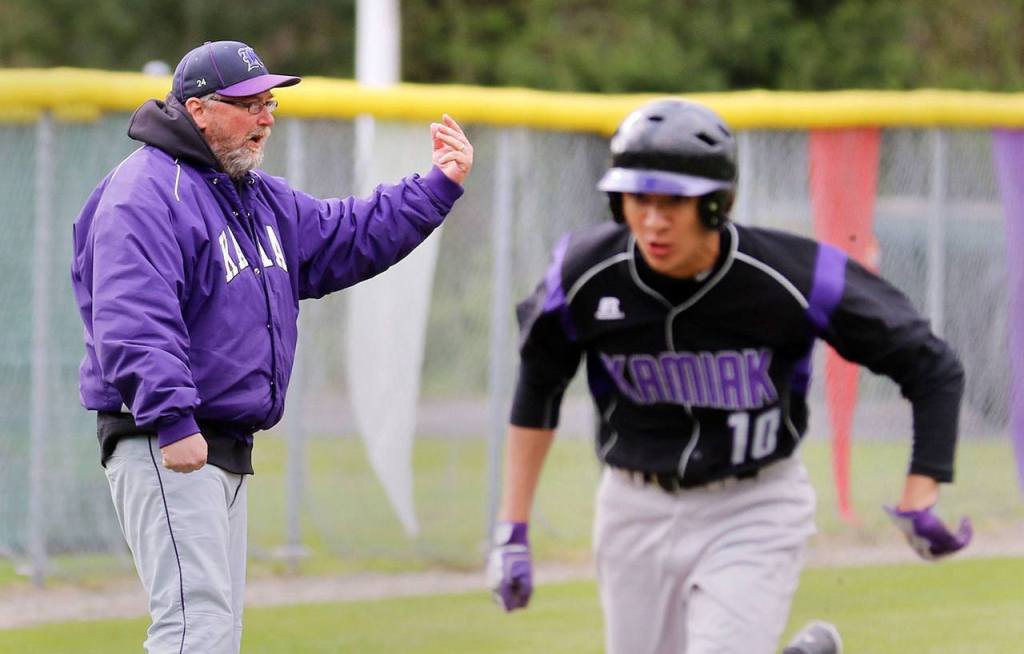 Former Kamiak baseball coach Frank Nickerson waves on another runner as Dominic Nickerson runs for home during a game against Mariner on April 3, 2015, at Kamiak High School in Mukilteo. (Kevin Clark / The Herald)