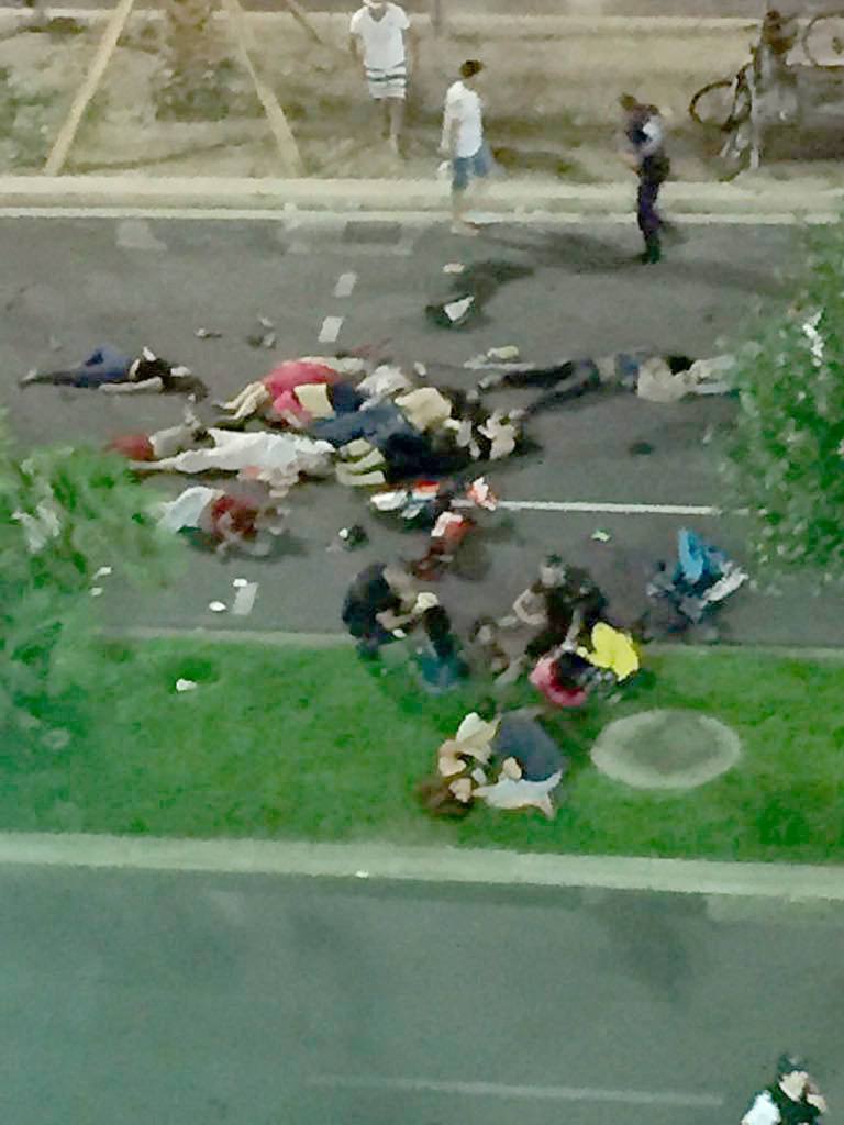 Authorities care for the wounded after a truck drove onto a sidewalk for more than a mile, plowing through a Bastille Day crowd. (Christopher Williams/AP)