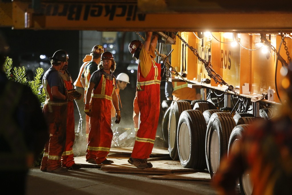 Hansen Bros workers make adjustments during the relocation of the historic Weyerhaeuser Office Building along West Marine View Drive in Everett early Thursday. (Ian Terry / The Herald)