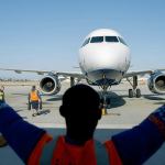 A worker guides a JetBlue Airways aircraft at Long Beach Airport in Long Beach, California, on April 25. (Patrick Fallon / Bloomberg)