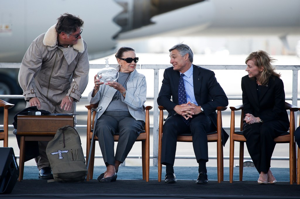 June Boeing (center left) is given a gift to mark Boeing&rsquo;s 100th year anniversary as vice chairman Ray Conner (center right) and executive vice president Leanne Caret look on at Boeing Field in Seattle on Friday. (Ian Terry / The Herald)