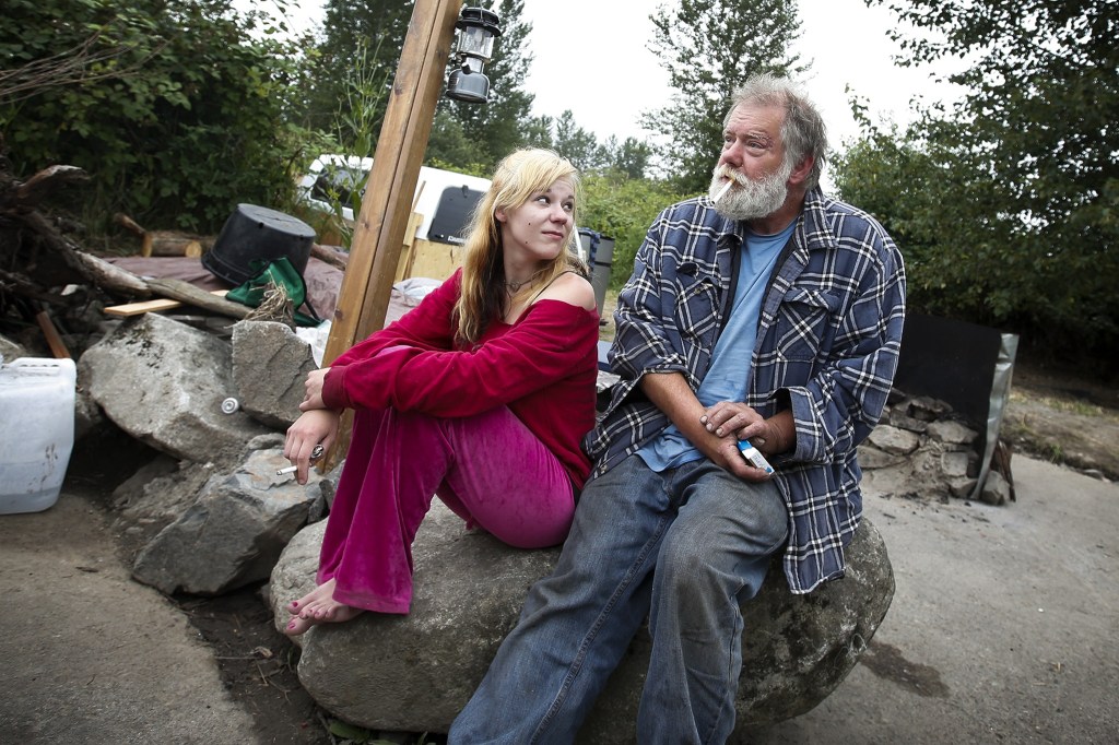 Howard Stone (right), 58, and Karisa Cak-Wigen, 24, sit and smoke a cigarette together on June 29 before Stone left the Lowell Snohomish River Road encampment where he typically spends the night to look at an apartment in downtown Everett that Snohomish County Sheriff&rsquo;s deputies and social workers had found for him. Stone later declined the apartment saying he didn&rsquo;t feel as safe there as he does at the Lowell encampment where him and a few others have permission from the property owner to stay. (Ian Terry / The Herald)