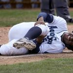 The AquaSox&rsquo;s Kyle Lewis grabs his right knee after colliding with Dust Devils catcher Chris Mattison in Everett&rsquo;s 8-6 loss to Tri-City on Tuesday at Everett Memorial Stadium. Lewis, the Mariner&rsquo;s No. 1 draft pick, did not return to the game. (Andy Bronson / The Herald )