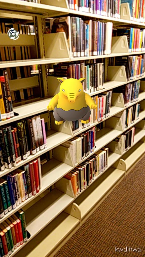 A Pokemon bops through the aisles of books at Everett Public Library.