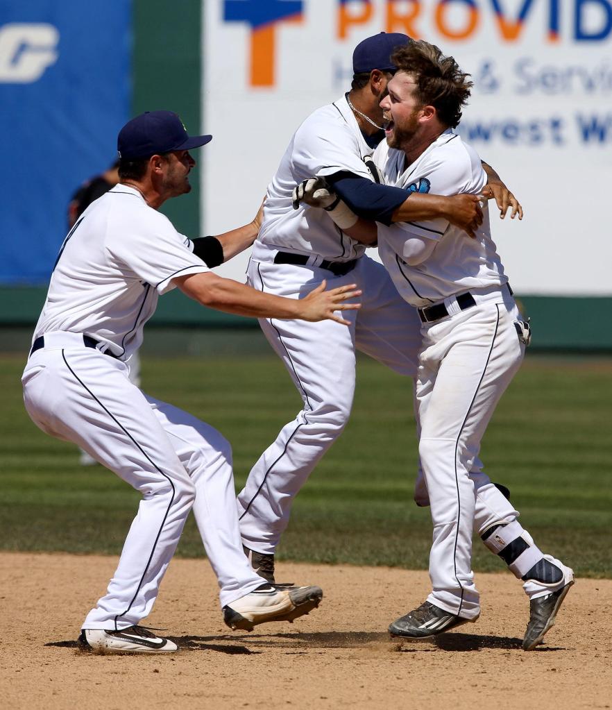 Everett AquaSox&rsquo; Eric Filia, right, is tackled by teammates Marvin Gorgas and Lane Ratliff, left, after Filia&rsquo;s walk-off two-run single gave Everett a 6-5 come-from-behind win over the Vancouver Canadians at Everett Memorial Stadium on Wednesday, July 27, 2016 in Everett, Wa. ( Andy Bronson / The Herald )