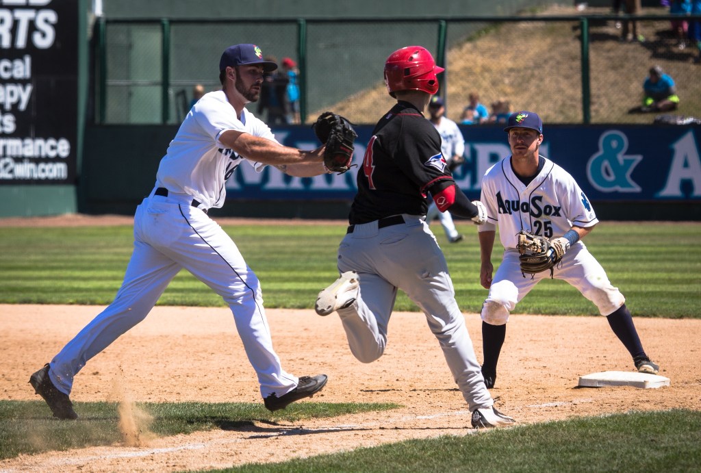 AquaSox Nick Thurman, left, tags out the Vancouver Canadians&rsquo; Cavan Biggio as AquaSox Donnie Walton looks on. A walkoff two-run single later gave Everett a 6-5 come-from-behind win over the Vancouver Canadians on Wednesday before 4,379 fans on Kidճ Day at Everett Memorial Stadium.(Daniella Beccaria / For the Herald)