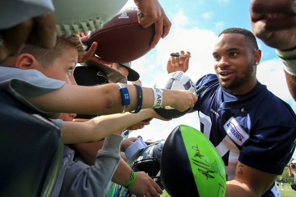 Seahawks running back Thomas Rawls signs autographs after the first day of training camp Thursday at the Virginia Mason Athletic Center in Renton. Rawls did not practice. (Kevin Clark / The Herald)