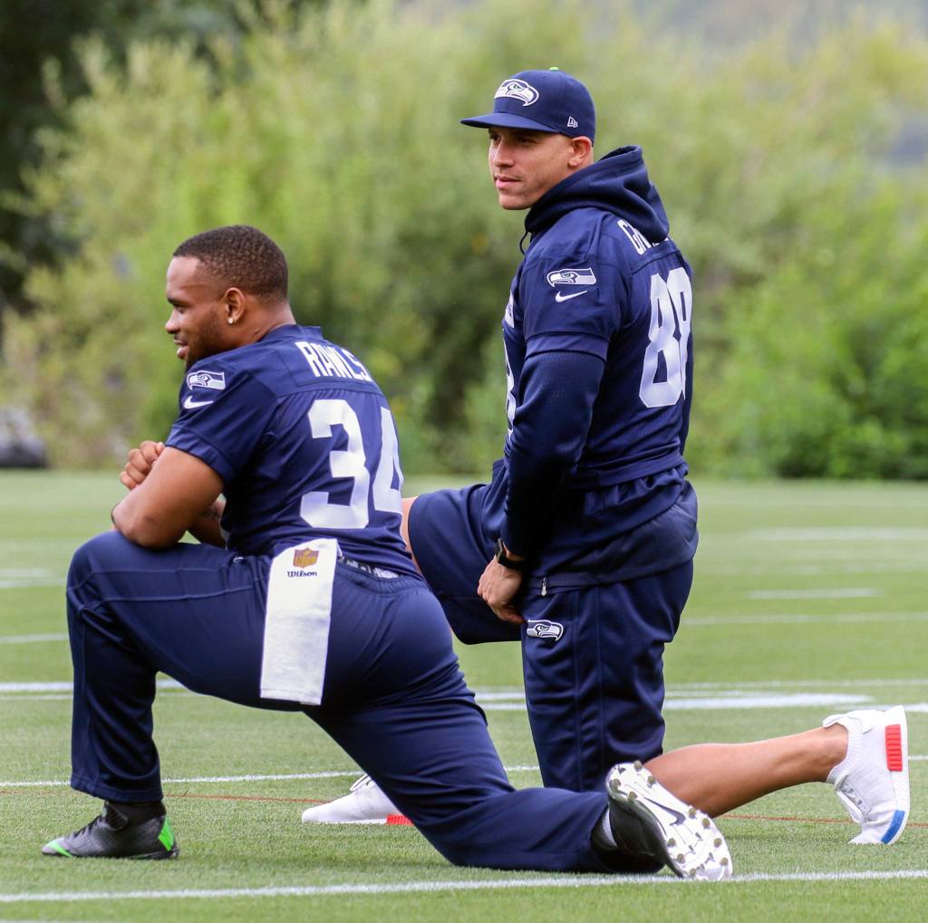 Seahawks running back Thomas Rawls (left) and tight end Jimmy Graham stretch on the first day of training camp Saturday at the Virginia Mason Athletic Center in Renton. Neither player practiced as both are recovering from surgery. (Kevin Clark / The Herald)
