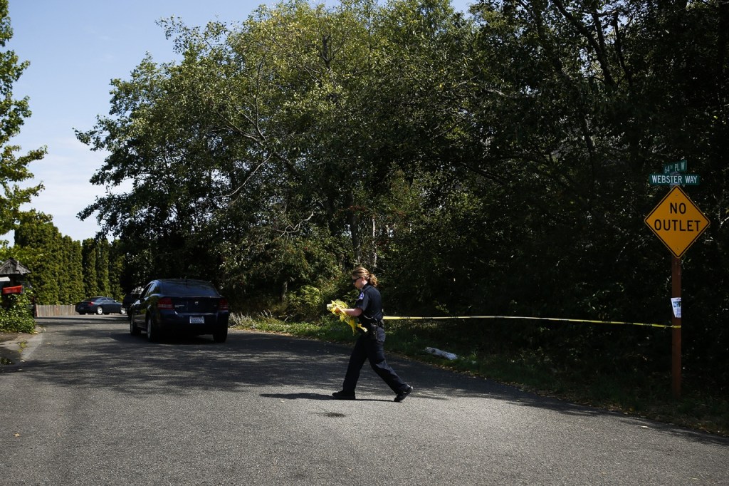 A police officer cordones off 64th Place West in the Chennault Beach area of Mukilteo on Saturday morning after a shooting at a home left three dead and one injured. (Ian Terry / The Herald)