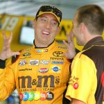 Kyle Busch (18) talks to a crew member in the garage area at Pocono Raceway during practice for Sunday&rsquo;s NASCAR Sprint Cup Pennsylvania 400 on Friday in Long Pond, Pa. (AP Photo/Mel Evans)