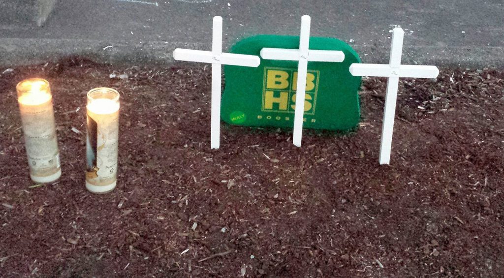 John Conley, father of 15-year old Molly Conley, who was gunned down by a stranger in 2013 while walking with her friends, brought three small white crosses Saturday to leave at the memorial in the Kamiak High School parking lot. (Sharon Salyer / The Herald)