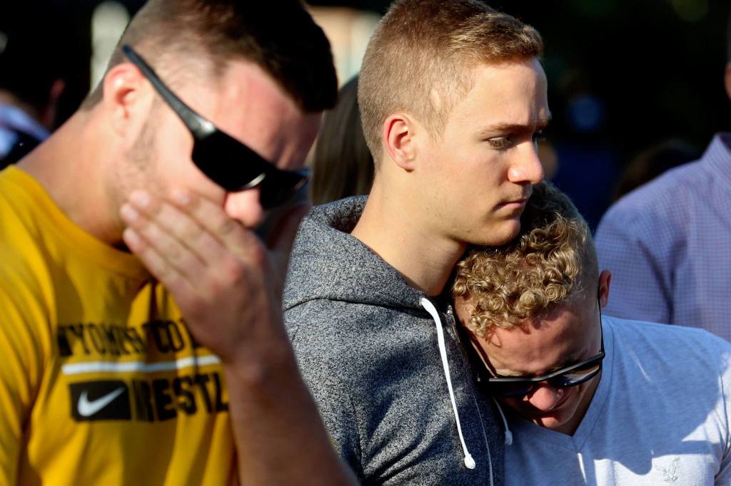 Friends and family gather to remember the slain at a Sunday night vigil. (Kevin Clark / The Herald)