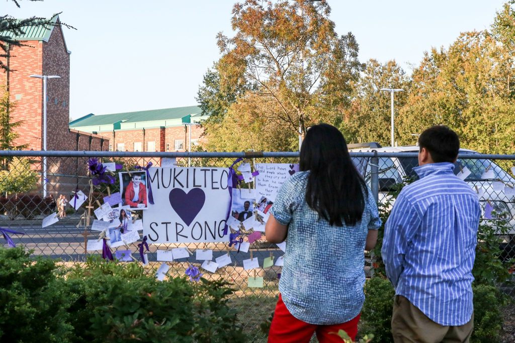 Friends and family gather to remember the slain at a Sunday night vigil. (Kevin Clark / The Herald)