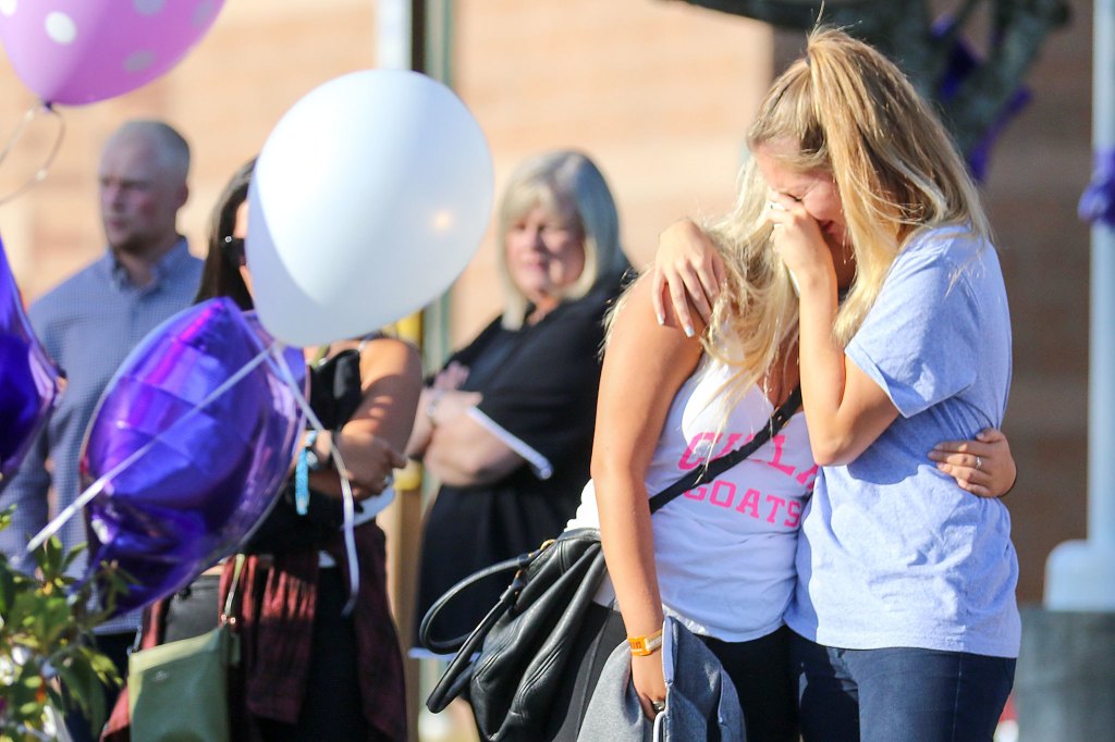 Friends and family gather to remember the slain at a Sunday night vigil. (Kevin Clark / The Herald)