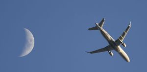A passenger plane that took off from Denver International Airport passes by the moon while heading west over Commerce City, Colorado, on May 11.
