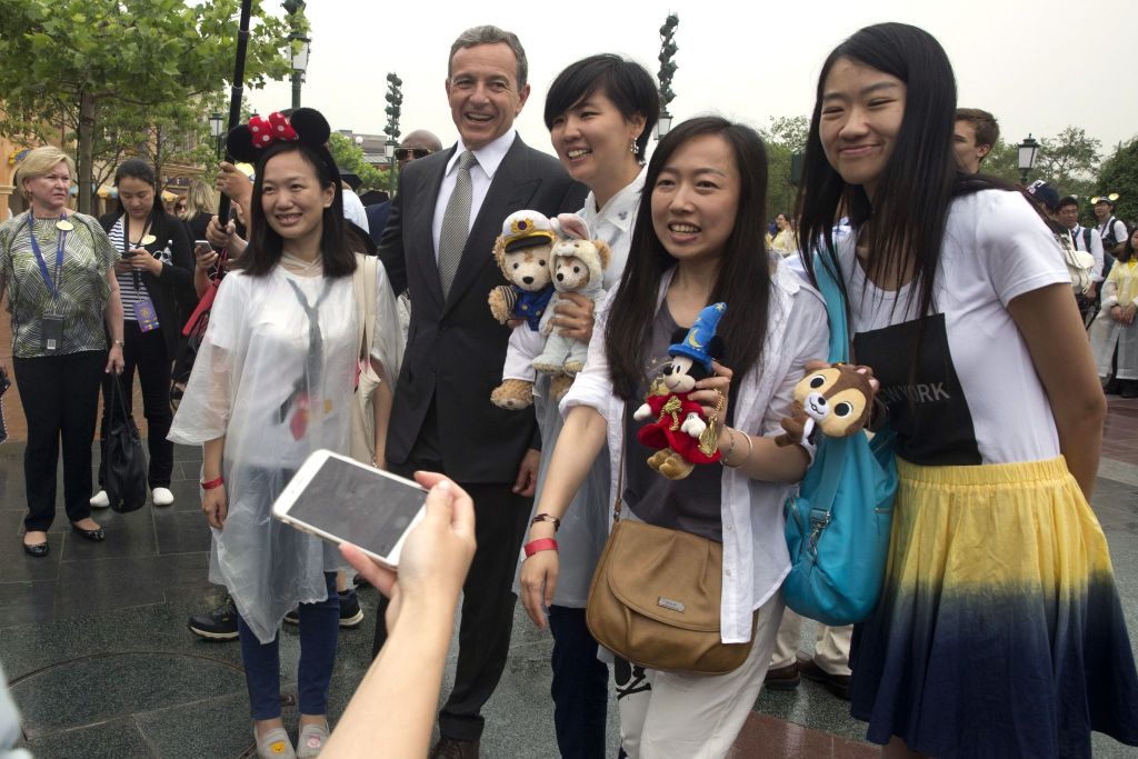 Disney CEO Bob Iger poses with visitors at the Disney Resort in Shanghai on Thursday.