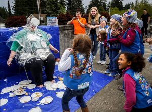 Fellow Girl Scout Daisies react when Payton Camacho&rsquo;s whip cream pie toss lands right on troop leader Tina Fish&rsquo;s face Thursday night in the parking lot outside New Life Church in Everett.