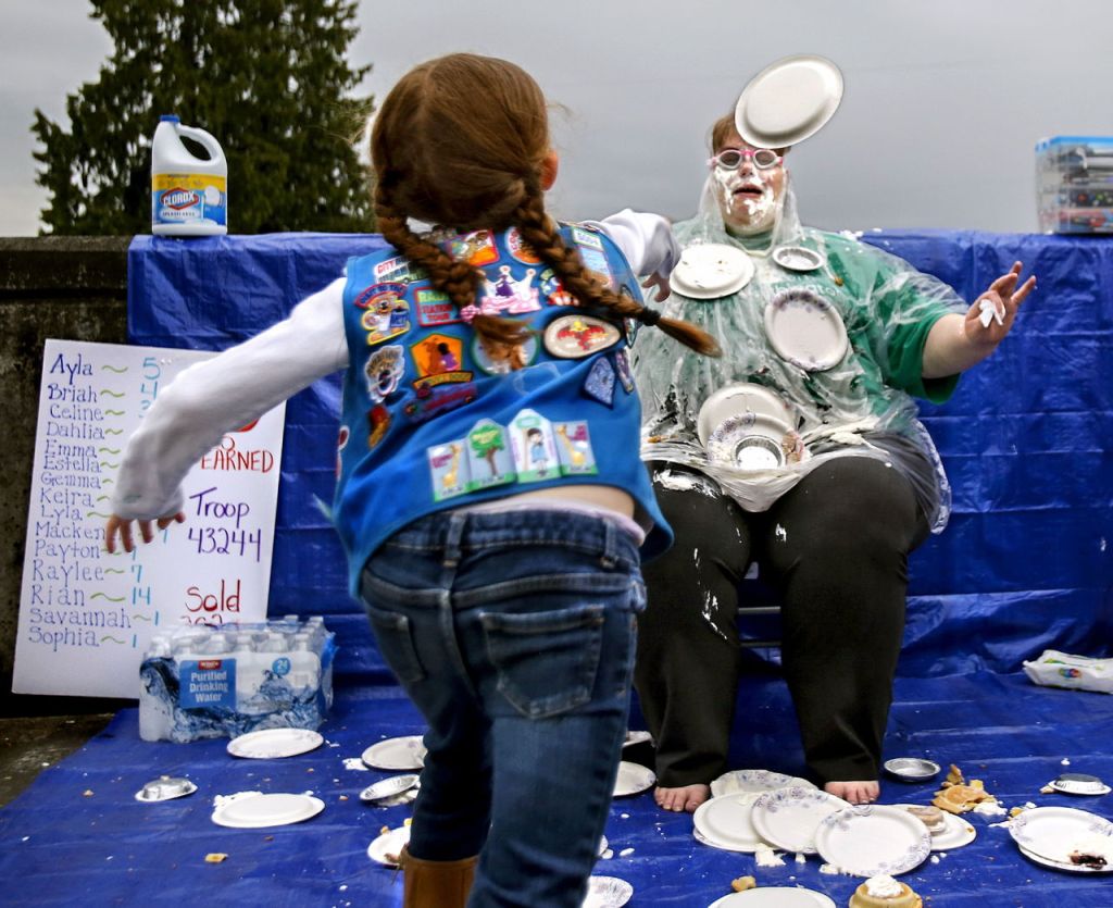 Girl Scout Daisy Payton Camacho, 7, lets fly with a whip cream pie that is right on the mark for troop leader &ldquo;Miss Tina&rdquo; on Thursday night in the parking lot outside New Life Church in Everett.