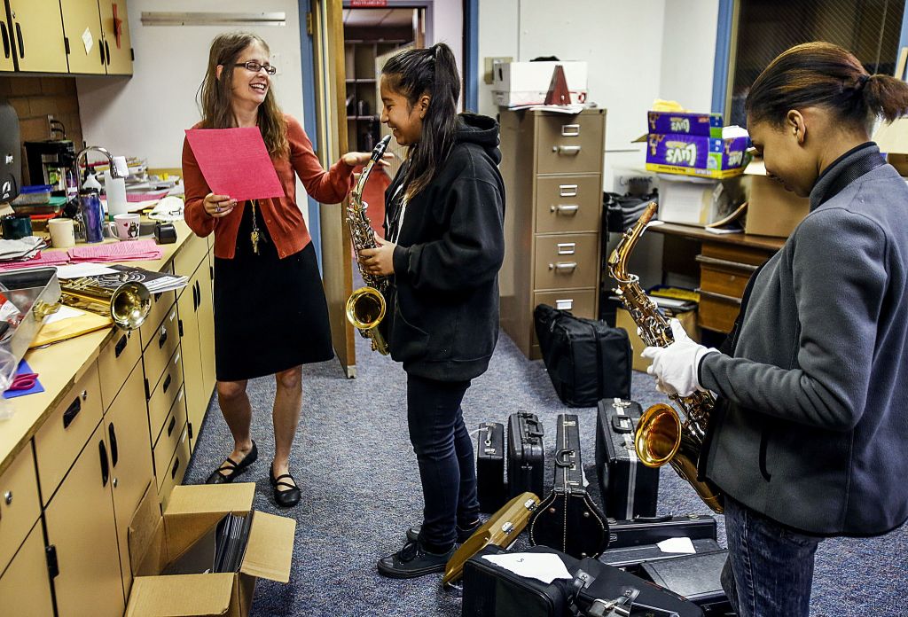 North Middle School band and choir director, Emily Cheever talks to Lisbet Margarito, 12, regarding her instrument, while Hannah Wells waits in a workroom adjacent to the main studio.