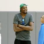 Kevin Durant talks with Golden State Warriors assistant coach Ron Adams (right) before a news conference Thursday in Oakland, California. (AP Photo/Beck Diefenbach)