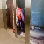 The stall doors in the women&rsquo;s bathroom depict latrines used by millions of people in developing nations.
