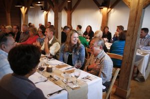 Amy Gorman (center), of Camano Island, laughs as Tino Senon (right) tells a story during the June 11 dinner at Kristoferson Farm on Camano Island. The five-course dinners feature food paired with wines from a visiting vineyard.