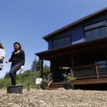 Clearwater Commons resident Joanne Lane (left) and real estate agent Lucy Stephens walk out of a home currently for sale.