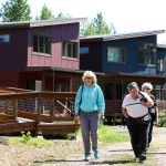 Brook Madrone (left) and Dena Petersen (center left), of Seattle, walk past homes with other visitors to Bothell&rsquo;s Clearwater Commons eco-housing community Saturday.