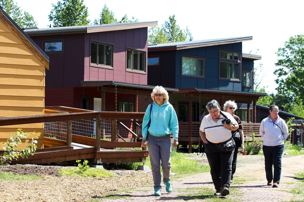 Brook Madrone (left) and Dena Petersen (center left), of Seattle, walk past homes with other visitors to Bothell&rsquo;s Clearwater Commons eco-housing community Saturday.