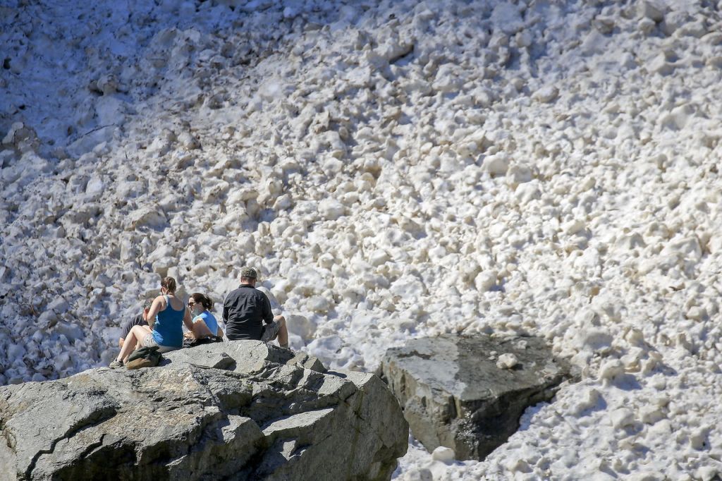People enjoy the view of the snow pack Sunday morning at the Big Four Ice Caves in Granite Falls. The popular hike and attraction has been closed since a deadly collapse killing two people in July 2015.