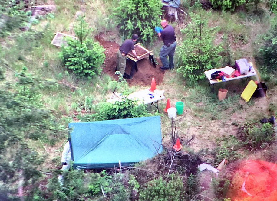 Seen from the air on Tuesday, detectives work at the scene near Oso where the bodies of a man and a woman were found. The couple are thought to be Patrick Shunn and Monique Patenaude, who have been missing since April and are presumed murdered.