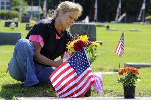 Linda Burns decorates the grave sites of her husband&rsquo;s relatives at Marysville Cemetery on Memorial Day morning Monday.