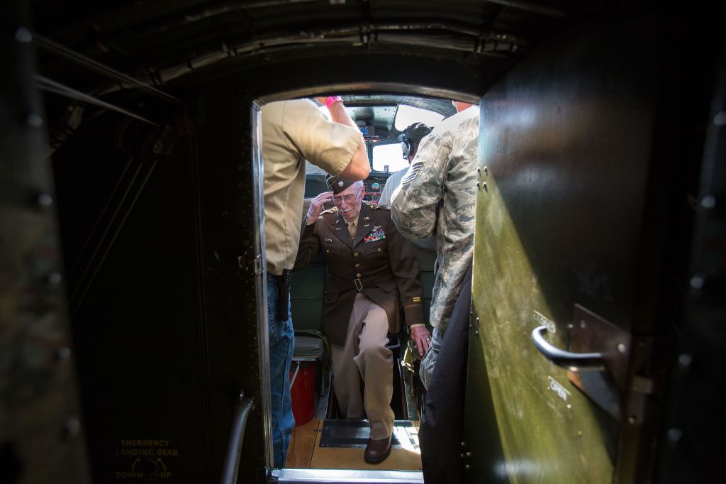 Climbing out from the nose of the Aluminum Overcast, B-17 navigator retired Lt. Col. Ken Wheeler gets and returns a salute from the Experimental Aircraft Association&rsquo;s Terry Tucker (left) during a flight Monday from Boeing Field in Seattle. Thirteen veterans, who fought WWII in B-17s, met for a D-Day reunion and many took a flight over Seattle in the bomber.
