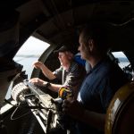 From a waist gunner&rsquo;s position, B-17 bomber veteran Dick Nelms (left) talks with his son, Garet, as they fly on the Aluminum Overcast.