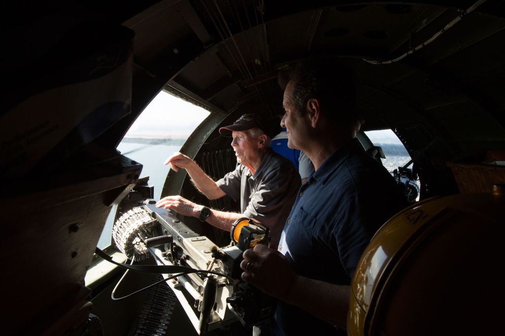 From a waist gunner&rsquo;s position, B-17 bomber veteran Dick Nelms (left) talks with his son, Garet, as they fly on the Aluminum Overcast.