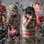 Kids beat the heat Friday by playing in the new spray pad at City Park in Edmonds.