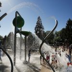 Water cascades onto kids playing in the new spray pad Friday at City Park in Edmonds.