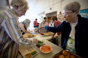 Pat Bronson serves food to Mary Bool at Our Savior&rsquo;s Lutheran Church in Stanwood on May 12. Local churches are celebrating 10 years of The Gathering Place, a program created to feed people in need.