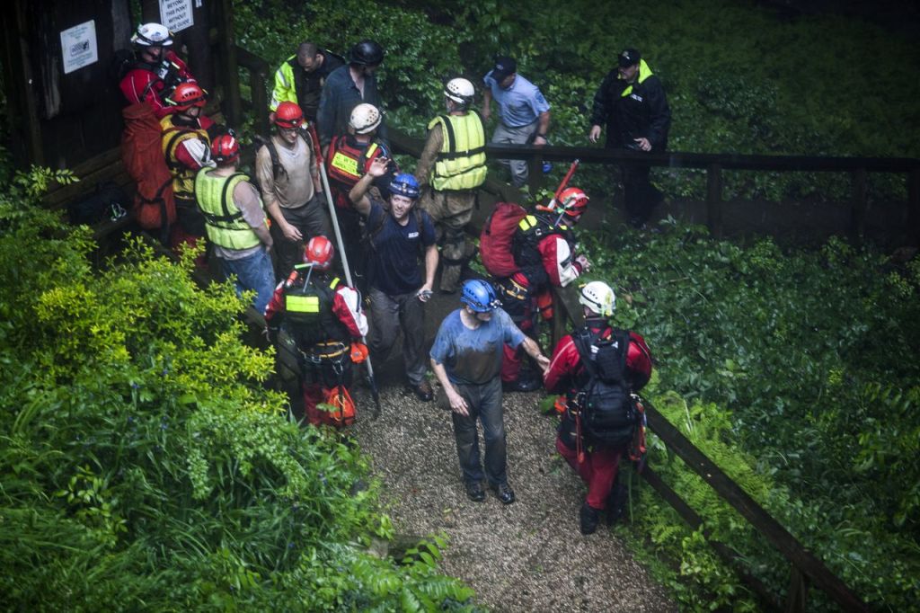 People who were rescued from Hidden River Cave exit the cave on Thursday.