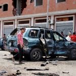 People gather at the scene after a pair of suicide bombings attack in the southern city of Aden, Yemen, on Monday.