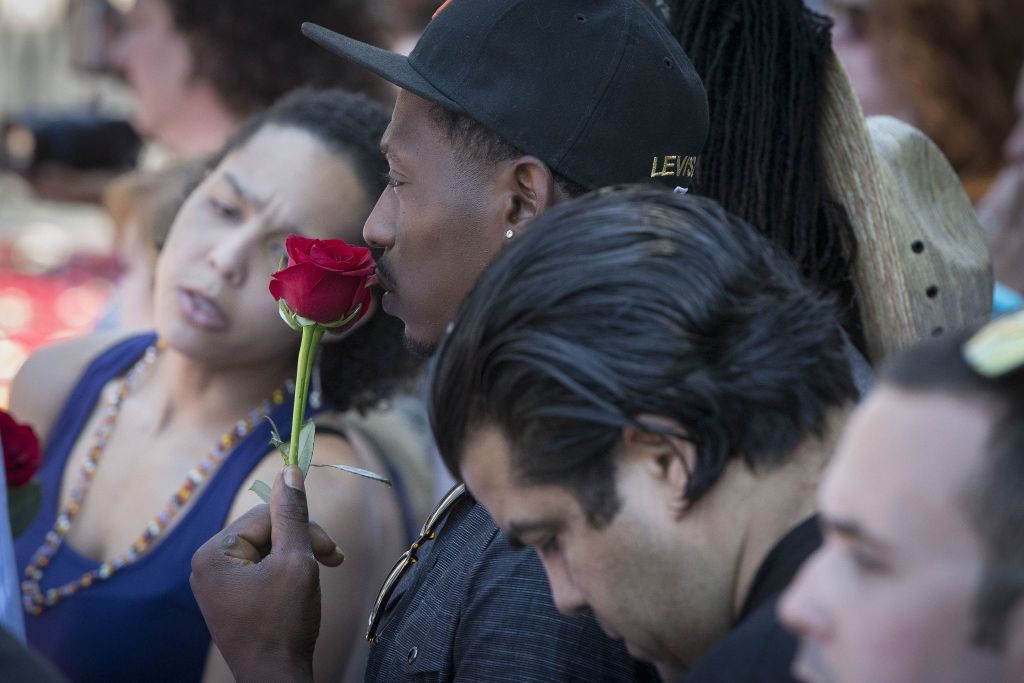 A spectator holds a rose as he waits for the arrival of Muhammad Ali&rsquo;s funeral procession to enter Cave Hill Cemetery. Ali&rsquo;s body will ride in a miles-long procession spanning his life &mdash; from his boyhood home, where he shadowboxed and dreamed of greatness, to the boulevard that bears his name and the museum that stands as a lasting tribute to his boxing triumphs and his humanitarian causes outside the ring.