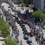 Ali&rsquo;s funeral procession passes as onlookers line the street.