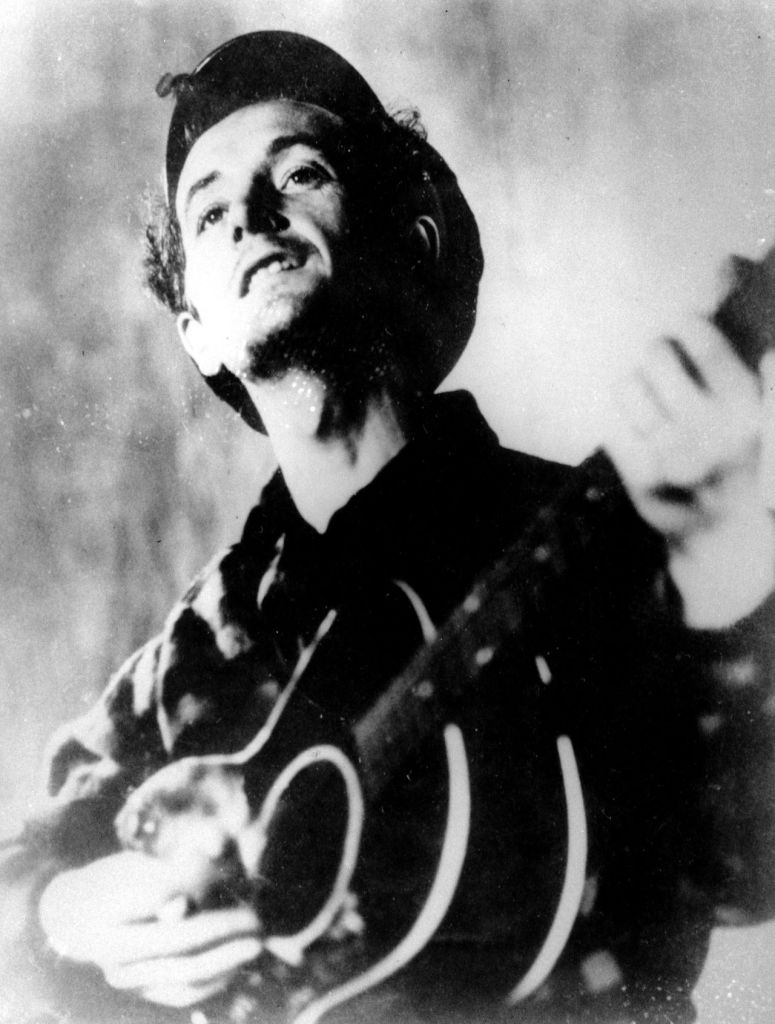 In this undated photo folk singer Woody Guthrie plays his guitar.