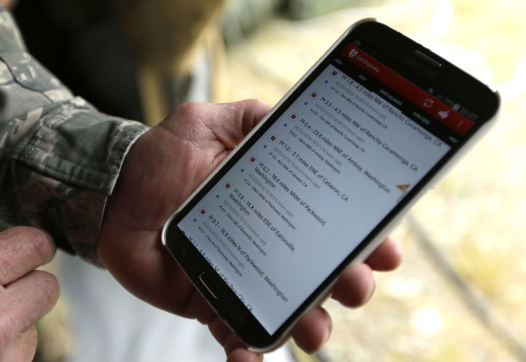 Washington Air National Guard Lt. Col. Curt Puckett, commander of the Guard&rsquo;s 141st Civil Engineer Squadron based at Fairchild Air Force Base in Spokane, checks an app on his phone that tracks global earthquake activity while his soldiers work at Joint Base Lewis-McChord.