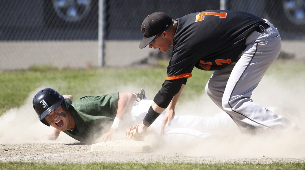 Jackson runner Carter Booth (left) slides into third base safely as Monroe&rsquo;s Ryan Witt applies a tag during a 4A district opener game at Jackson High School on Saturday, May 7, 2016. Jackson went on to defeat Monroe 10-7.