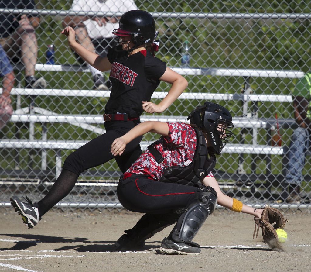 Cedarcrest&rsquo;s Michaela Carter (left) runs safely into home plate for an inside the park home run in the first inning as Archbishop Murphy catcher Alyson Matriotti fields the ball during a game Wednesday at Archbishop Murphy High School. Cedarcrest won 8-6.