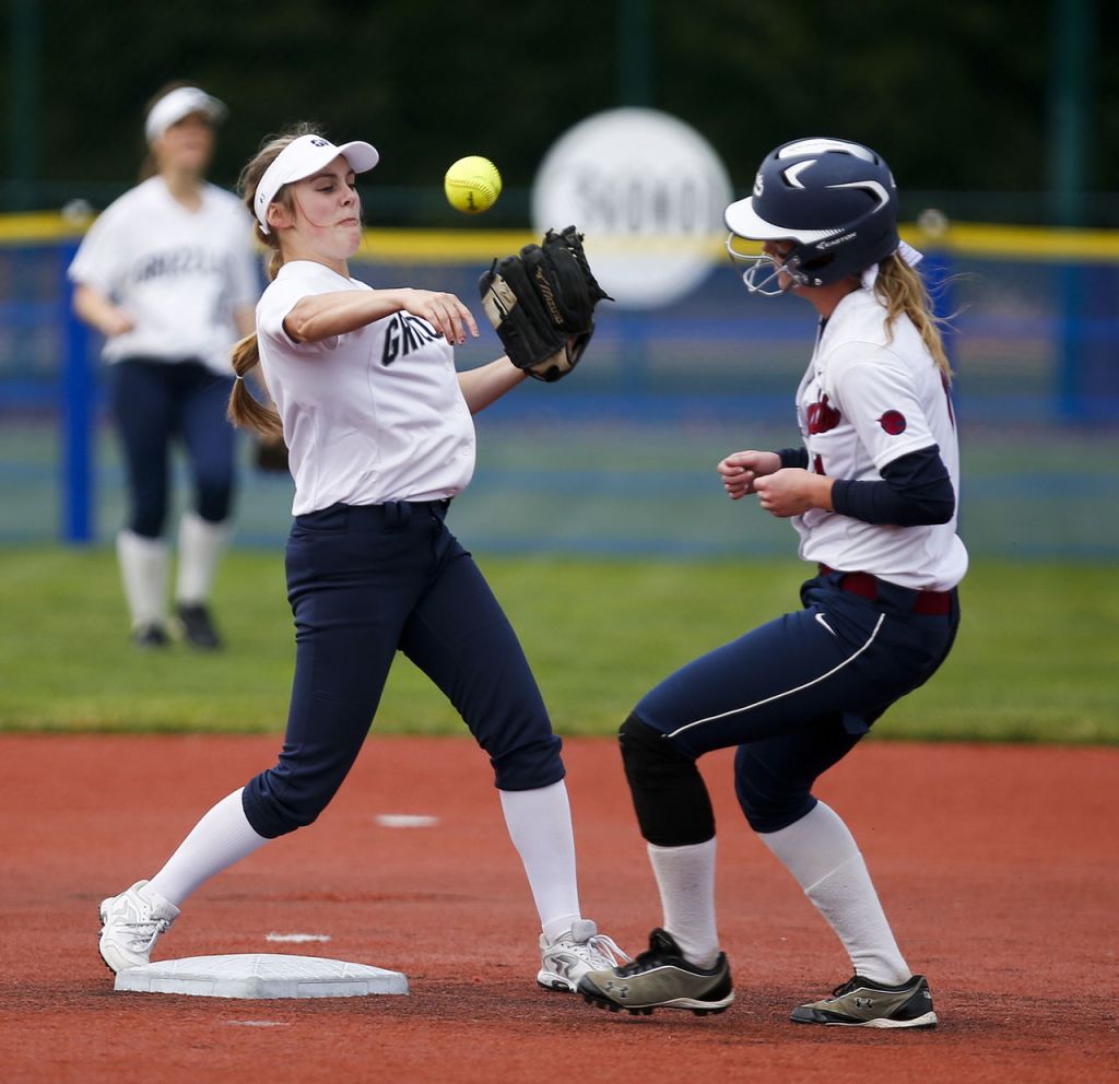 Glacier Peak&rsquo;s Kendall Curtis (left) throws a ball to first base on a double play attempt as Mt. Spokane&rsquo;s Jolene House runs into second base during a first-round game of the 3A state softball tournament Friday in Lacey.