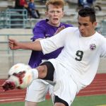 Edmonds Woodway&rsquo;s Jose Aleman-Cruz kicks the ball with Garfield&rsquo;s Owen Riddick trailing during a 3A state tournament match on May 20 at Edmonds Stadium.