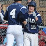 Arlington&rsquo;s Kyle Bayer (4) is greeted at the dugout by Tristan Sheward after Bayer scored the Eagles first run during Sunday&rsquo;s game against Lakeside.