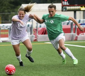 Edmonds-Woodway&rsquo;s Madison Schultz (left) and Riketo Sokoli battle for control of the ball during a charity match to raise money for the Special Olympics on Friday night at Edmonds Stadium.